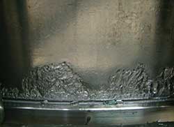 Contact fatigue spalling on a cone raceway resulting from edge loading due to misalignment and heavy loading.